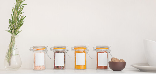 Jars with different spices on table in kitchen