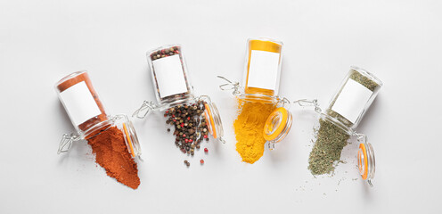 Overturned jars with different spices on light background, top view - obrazy, fototapety, plakaty