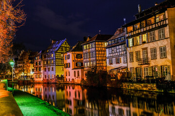 houses reflected in the water of the canal passing through the old quarter of Strasbourg in the evening