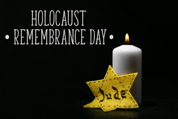 Burning candle and David star on dark background. Holocaust Remembrance Day