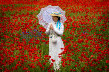 Woman in 19th century dress in a field of poppies