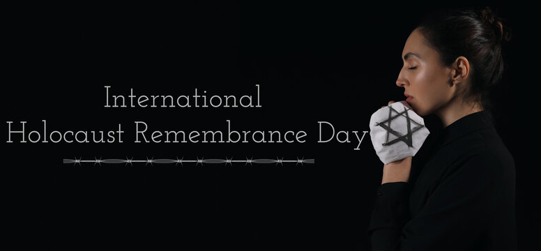 Jewish woman honoring victims of Holocaust on dark background