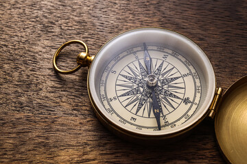 Fototapeta na wymiar Golden compass on wooden background, closeup