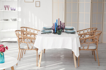 Dinnerware and eucalyptus branches on served table in light room