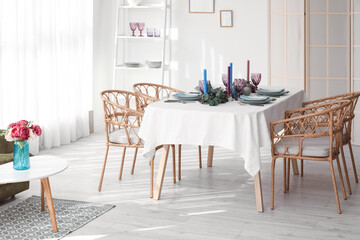 Dinnerware and eucalyptus branches on served table in light room