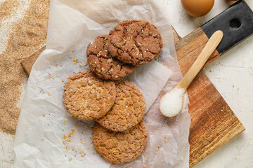 Wooden board with delicious cookies on light background, closeup