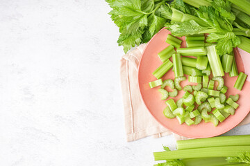 Plate of cut fresh celery on light background