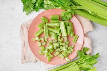Plate of cut fresh celery on light background