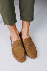 Male feet in brown suede casual shoes. Men's fashionable shoes