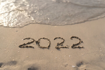 The numbers 2022 are washed away by the sea waves of the Persian Gulf. The concept of a change of years