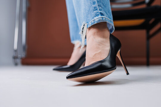 Beautiful female legs in jeans and black leather stilettos. Women's winter shoes