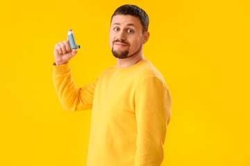 Man with inhaler on yellow background