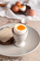 Plate with soft boiled egg and toast on table