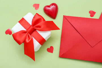Gift with hearts and envelope on green background. Valentine's Day celebration
