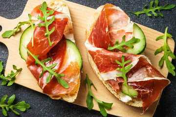 Open sandwiches with cream cheese, prosciutto, cucumber and arugula.