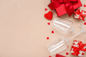 Glasses with gifts and hearts on beige background. Valentine's Day celebration