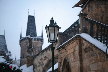 View of snow-covered street light on the Charles Bridge on the Vltava River, Czechia