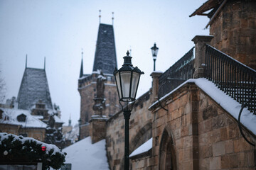 View of snow-covered street light on the Charles Bridge on the Vltava River, Czechia