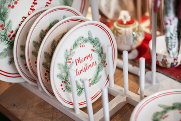 Fototapeta na wymiar Merry Christmas plates for home decor. Festive tableware or kitchenware in the store for winter holiday shopping. Buying gifts for Xmas.
