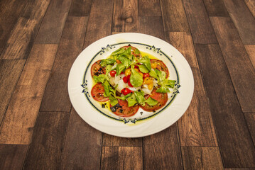 It is a cold salad whose ingredients are: shredded cod, Italian green pepper and red pepper cut into pieces, onion, olives and tomato. Season with olive oil, vinegar and, if necessary, salt