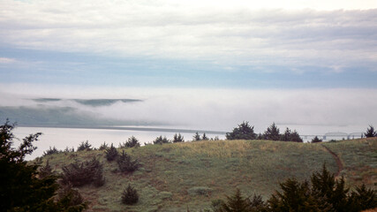 Fog bank moving over the Missouri River, railroad bridge and railway near Chamberlain, North Dakota, USA