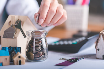 Man puts coins into a glass jar,concept of a loan for housing,Approval of credit for the purchase of real estate,business and finance concept,home loan refinancing,Financial wealth management