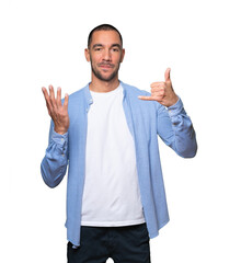 Hesitant young man making a gesture of calling with the hand