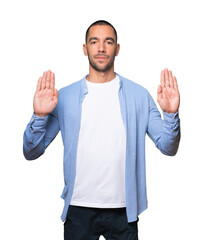 Serious young man making a gesture of stop with his palm