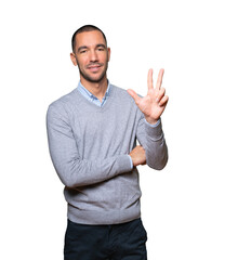 Fototapeta premium Young man making a number three gesture