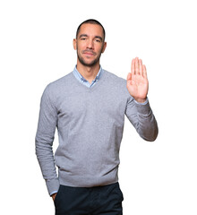 Happy young man making a gesture of stop with his palm