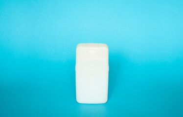 White square bottle for liquid soap, shampoo, gel on blue background.