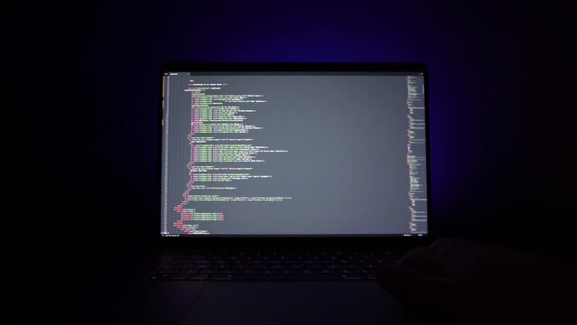 hacker: hacker who writes code. man working on laptop in night light