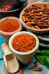 Colorful ground spicy chili peppers , pimento and curcuma is clay pots close up