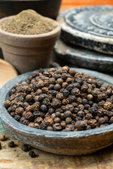 Indian spices collection, dried black peppercorns and another spices in clay bowls