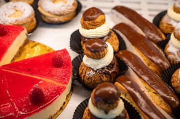 Assortment of french fresh baked sweet pastry with fresh fruits and berries in confectionery shop