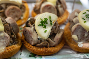 French mini quiche pie with goat cheese and traditional French sausage Andouillette from Troyes in bakery