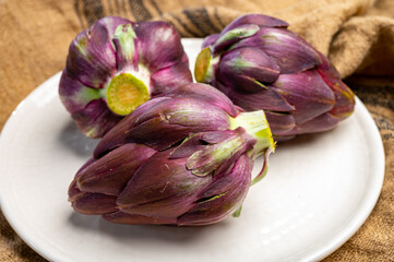 Heads of raw fresh purple mini romanesco artichoke vegetable ready to cook