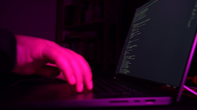 hacker: hacker who writes code. man working on laptop in night light