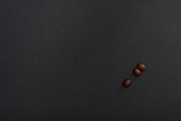 Three coffee beans on a black background, minimalistic design. Beauty is in simplicity