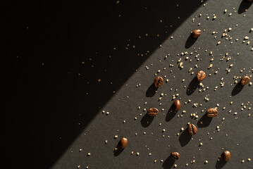 Coffee beans and cane sugar in a beam of light on a black paper background