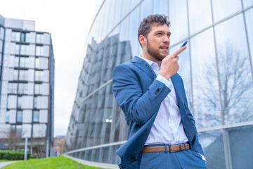 Professional corporate man businessman outside the office sending a voice memo