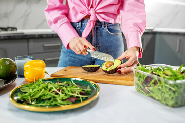 Hostess cuts vegetables and makes salad. Concept of eco-friendly products for cooking. Close up