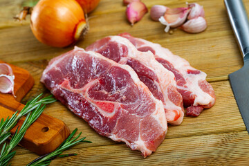 Cooking raw pork shoulder on wooden kitchen table. High quality photo