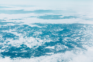 Snowy clouds over snowy mountains . Winter flight scenery 