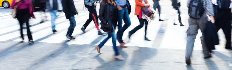 crowds of people crossing a city street