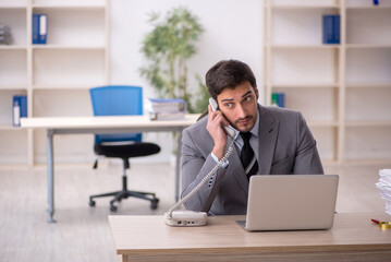 Fototapeta premium Young male employee and too much work in the office