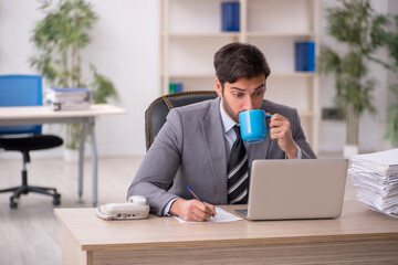 Young male employee drinking coffee during break