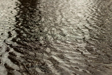 Waves on water. Wind on surface of water. Reflection in puddle.
