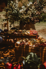 table with cold cuts, cheese, nuts and decoration plants.