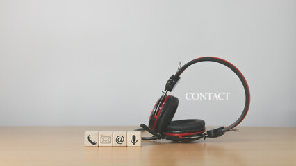 Website page, contact us or email marketing concept, customer support hotline, contact us. Wooden cubes with, email, phone, address, chat message icons on headphones